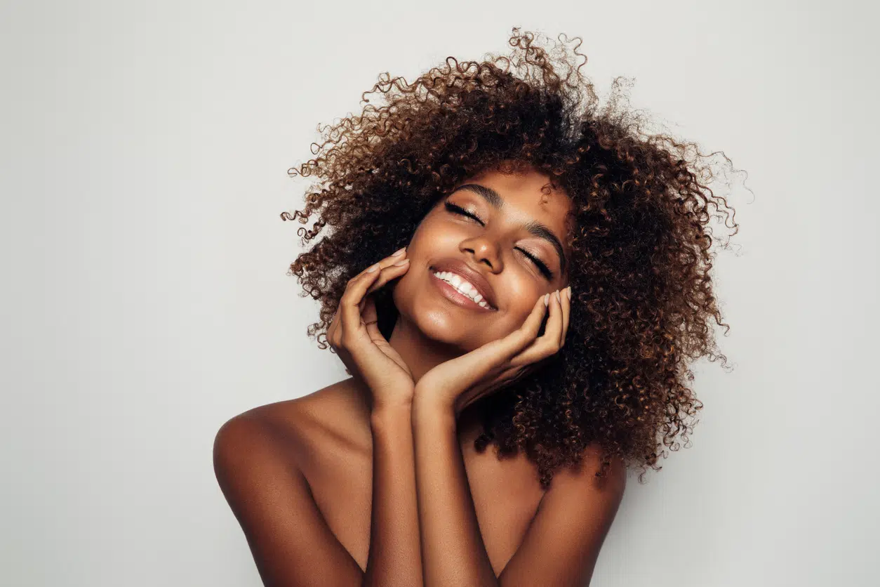 woman smiling touching face